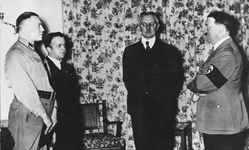 Hjalmar Schacht (en el centro), presidente del Reichsbank (1933-1939), en una fotografía de 1936. A su izquierda, Hitler. Atribución: Bundesarchiv, Bild 183-R98364 / CC-BY-SA 3.0. Vía Wikimedia Commons.